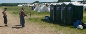 Einige in Uniformen des US-Bürgerkriegs gekleidete Männer stehen im Zeltlager vor einer Reihe Dixi-Toiletten. Gettysburg 7/2017. (c)A.Körber